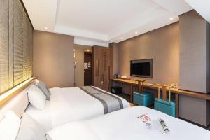 a hotel room with two beds and a flat screen tv at Confucius Temple Yisu Hotel in Gaoqiao