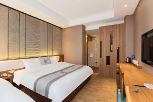 a hotel room with a large bed and a television at Confucius Temple Yisu Hotel in Gaoqiao