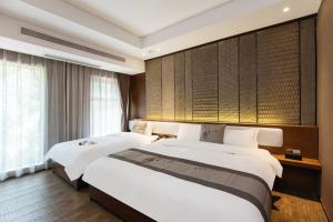 a hotel room with two beds and a window at Confucius Temple Yisu Hotel in Gaoqiao +44 photos