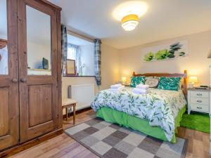 a bedroom with a bed with a green bedspread at 2 Bed in Launceston TILLI in Virginstow