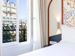 a bedroom with a bed and a window at ibis Styles Paris Eiffel Cambronne in Paris