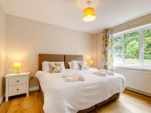 a bedroom with a large bed and a window at 4 Bed in Alsop-En-Le-Dale 88935 in Alsop en le Dale