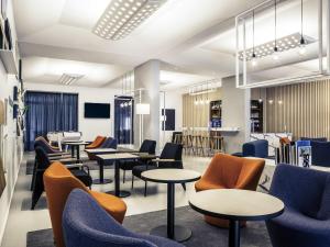 a waiting room with tables and chairs at Mercure Nancy Centre Gare in Nancy