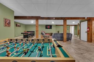 a room with a pool table with dolls on it at Secluded Log Cabin with Hot Tub Fire Pit Game Room in Newfoundland