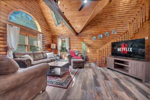 a living room with a television in a log cabin at Secluded Log Cabin with Hot Tub Fire Pit Game Room in Newfoundland +59 photos
