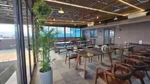 a dining room with tables and chairs and plants at Serena Tam Coc Hotel & Villa in Ninh Binh