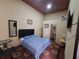 Un pequeño dormitorio con una cama y una mesa. en Hotel Prada, en Las Victorias