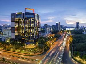 a city skyline with a tall building and a street at Grand Mercure Jakarta Kemayoran in Jakarta