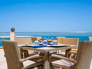 une table et des chaises en plein air avec une table, une table et des chaises dans l'établissement Pullman Resort Al Marjan Island, à Ras al Khaimah