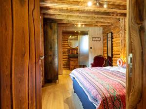 a bedroom with a bed in a log cabin at Spacious wooden chalet with covered terrace in Schaluinen