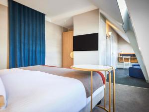 a hotel room with a bed and a table at l'Echiquier Opéra Hotel Paris - MGallery Collection in Paris