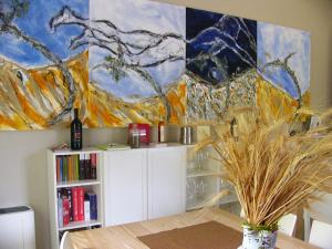 una stanza con un tavolo e un dipinto sul muro di Agriturismo Gallegati a Faenza