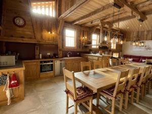une grande cuisine avec une table et des chaises en bois dans l'établissement Chalet spacieux à Samoëns, 6 chambres, idéal pour 14 personnes avec Wifi - FR-1-846-1, à Samoëns
