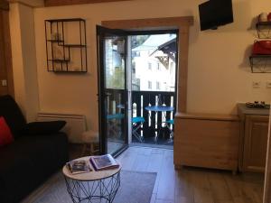 a living room with a door leading to a balcony at Studio cosy pour 4 à Samoëns - FR-1-846-4 in Samoëns
