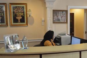a woman sitting at a cash register in a waiting room at El Dorado Inn in Georgetown