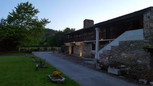 a stone building with a pathway next to a building at Casa Berdeal in Mañón