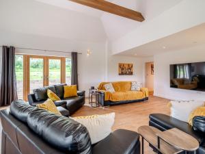 a living room with leather furniture and a tv at 5 Bed in Builth Wells 92709 in Beulah