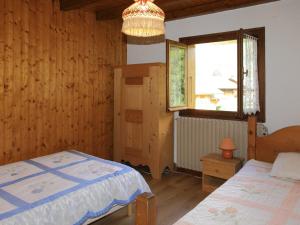 ein Schlafzimmer mit einem Bett und einem Fenster in der Unterkunft Charmante Villa à Samoëns avec Wifi et 2 Chambres - FR-1-846-34 in Samoëns
