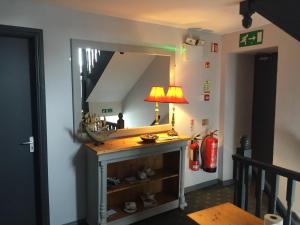 a room with a mirror and a table with a lamp at Roomz in Portaferry