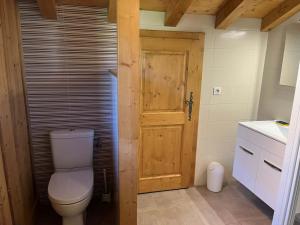 une salle de bain avec toilettes et porte en bois dans l'établissement Chalet pour 8 avec Wifi à Samoëns - FR-1-846-36, à Samoëns