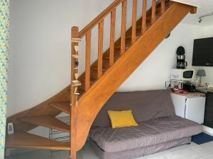 - un salon avec un canapé sous un escalier en bois dans l'établissement Maisonnette charmante - Proche plage et commerces - FR-1-482-161, à Royon