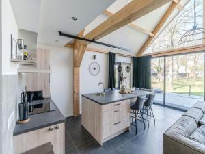 a kitchen and living room with a large window at Thatched bungalow with private terrace in Schaluinen