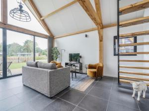 a living room with a couch and a table at Modern lodge stay with pond view in Schaluinen