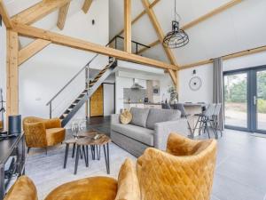 a living room with a couch and a table at Modern lodge stay with pond view in Schaluinen