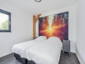 a bedroom with two beds with a large picture on the wall at Modern lodge stay with pond view in Schaluinen