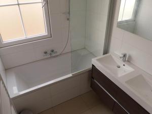 a bathroom with a tub and a sink and a shower at Spacious 10-Person Villa in Quiet Holiday Park in Schaluinen +12 photos