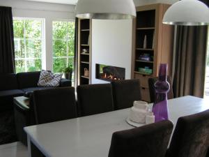 a living room with a table and a fireplace at Spacious 10-Person Villa in Quiet Holiday Park in Schaluinen