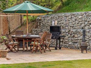 a patio with an umbrella and a table and chairs at 3 Bed in Godshill Wood 94495 in Godshill