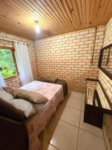 a room with two beds and a brick wall at Casa de sítio in Annitapolis