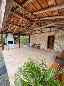 an outdoor patio with a fireplace and a wooden ceiling at Casa de sítio in Annitapolis
