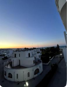 a view of a building with the sunset in the background at Appartamento a 20 metri dal mare San Salvo Marina in Marina di Montenero