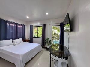 a bedroom with a bed and a glass table at DRB Siargao Apartments in General Luna