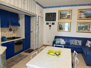 a kitchen and living room with blue cabinets and a table at Appartamento a 20 metri dal mare San Salvo Marina in Marina di Montenero +2 photos