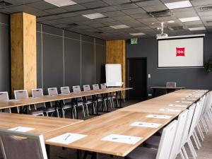 a conference room with tables and chairs and a whiteboard at Ibis Poznan Polnoc in Suchy Las