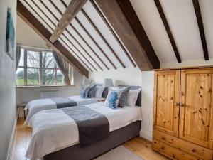 two beds in a bedroom with wooden ceilings at 2 Bed in Abbotsbury 92416 in Frome Vauchurch