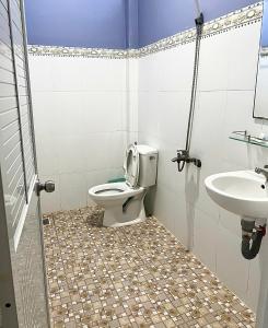 a bathroom with a toilet and a sink at Nhà Nghỉ Bi Ti in Ấp Long Sơn