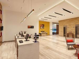 an office lobby with a desk with a computer on it at ibis Kochi City Centre - An Accor Brand in Cochin