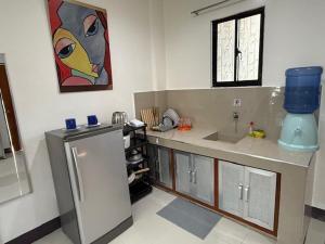 a kitchen with a sink and a refrigerator at DRB Siargao Apartments in General Luna