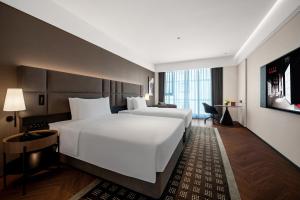 a hotel room with a large white bed and a desk at 上海虹桥中心城际酒店 in Shanghai +64 photos
