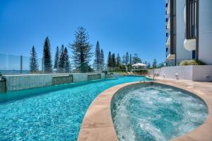 a swimming pool on the side of a building at 5-Star Beachfront Retreat with Theatre & Pool in Mooloolaba