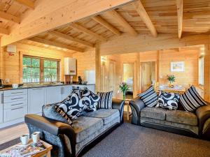 a living room with two couches and a kitchen at 2 Bed in Saxmundham 89929 in Snape