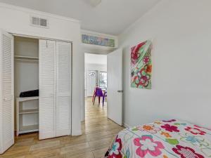 a bedroom with white walls and a bed with a colorful blanket at Coops Retreat Unit B in Tybee Island +15 photos