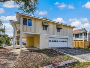 a large yellow house with a garage at Coops Retreat Unit B in Tybee Island