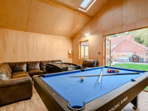 a living room with a pool table and a couch at 4 Bed in Aylsham 90094 in Stratton Strawless