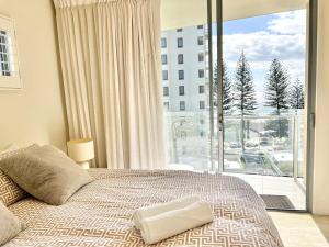 a bedroom with a bed and a large window at Luxury Coolangatta Sub-Penthouse Beach Abode in Gold Coast +22 photos