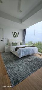 a bedroom with a large bed and a rug at Nala Host- 2BR Beachfront Apartment in Male City